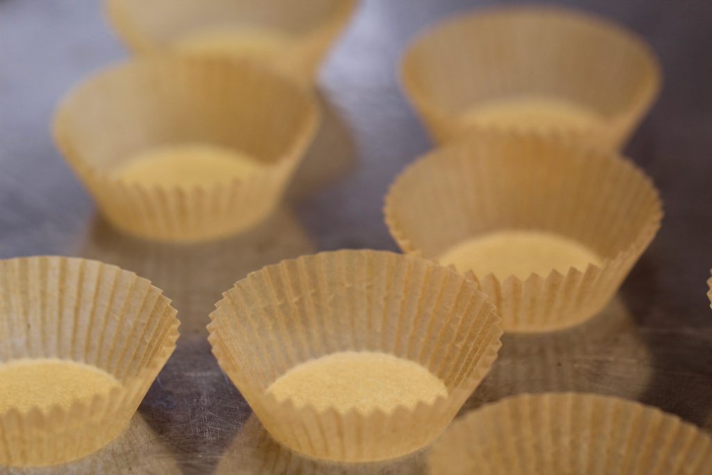 mini paper cupcake liners on a baking sheet