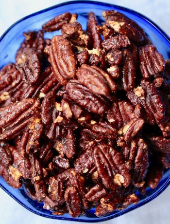 toasted mocha pecans in a blue glass bowl on a white cloth