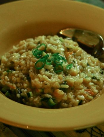 vegan summer risotto in a dark yellow bowl with a stainless steel spoon