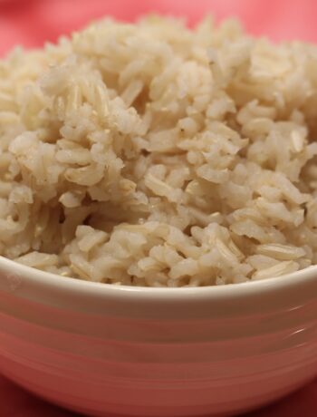brown rice in a white bowl on a red cloth