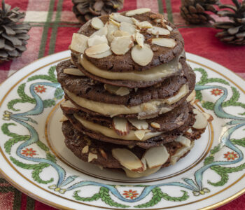 stack of sandwich cookies on white plate on red cloth