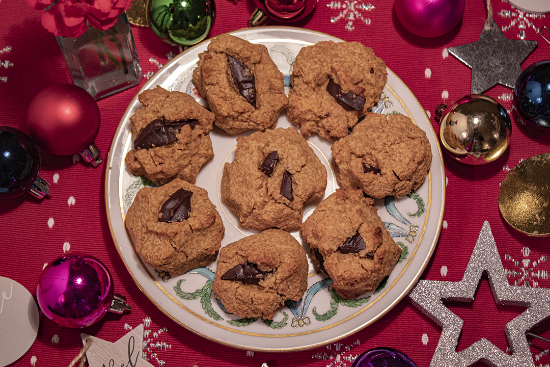 cookies on white plate on red cloth with Christmas decorations